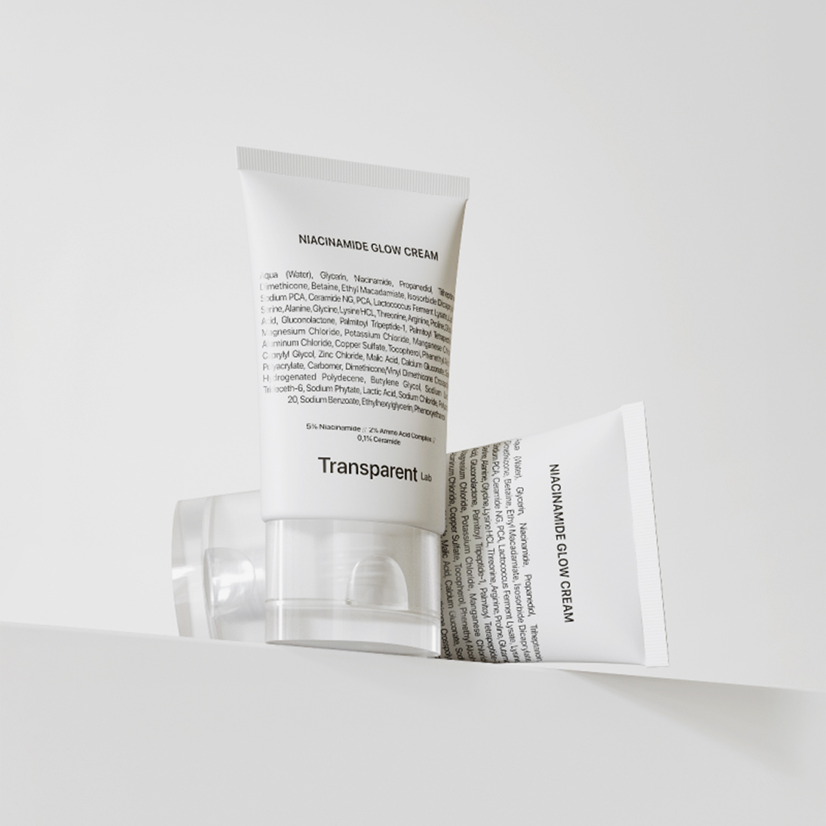 Zwei Tuben Niacinamide Glow Cream stehen auf einem hellen Sockel auf weißem Hintergrund.