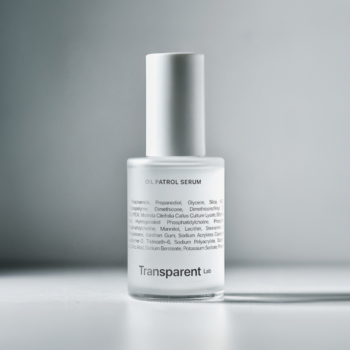 Eine weiße Flasche Oil Patrol Serum mit Textdetails auf hellgrauem Hintergrund.