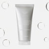Eine silberne Tube „Rose Calming Cleanser pH 5.5“ ist von durchscheinenden Blasen auf weißem Hintergrund umgeben.