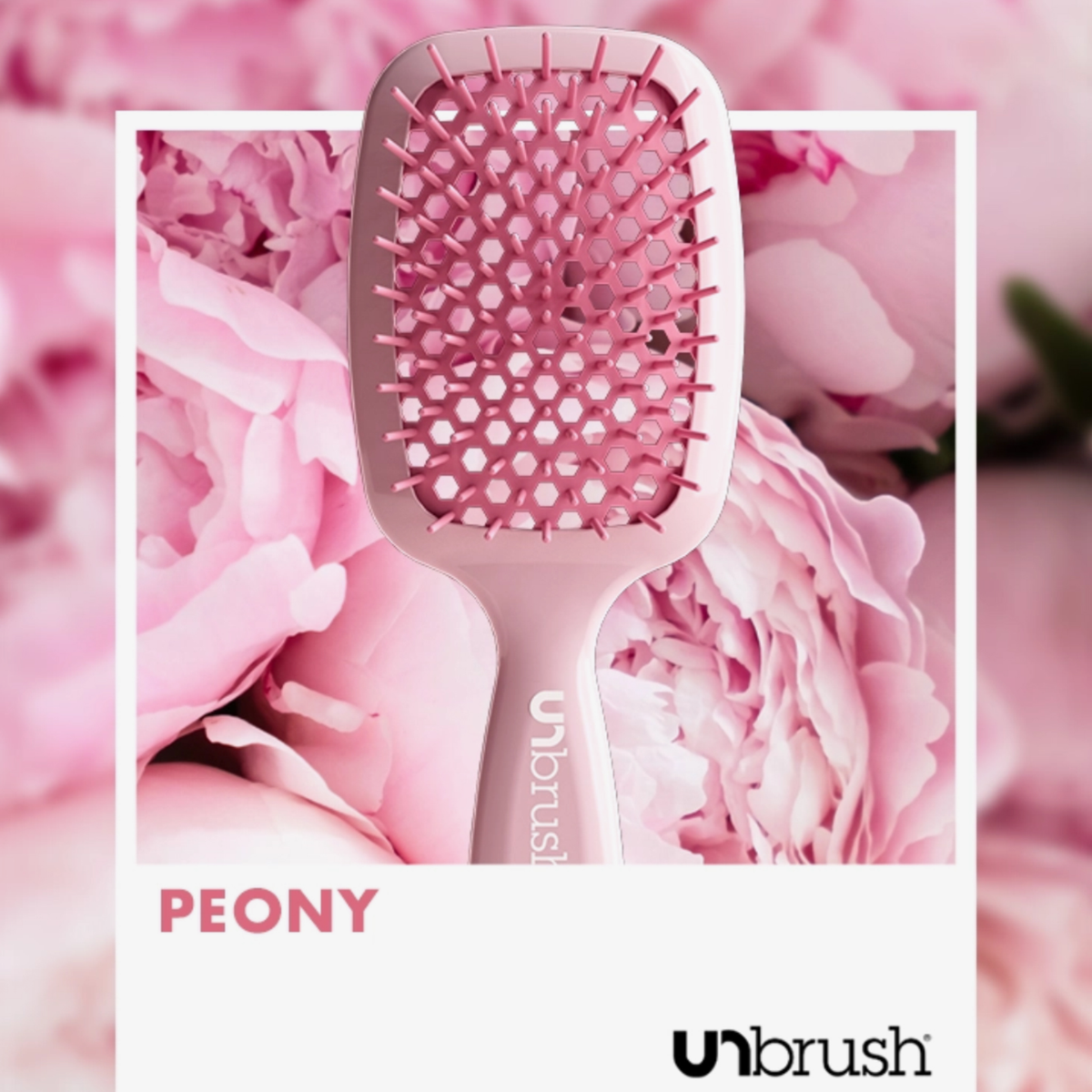 Eine Detangling-Haarbürste von UNbrush auf rosa Pfingstrosenblättern, mit den Logos PEONY und UNbrush am unteren Rand.