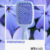 Eine hellviolette UNbrush Detangling Hair Brush auf einem Hintergrund aus immergrünen Blumen.
