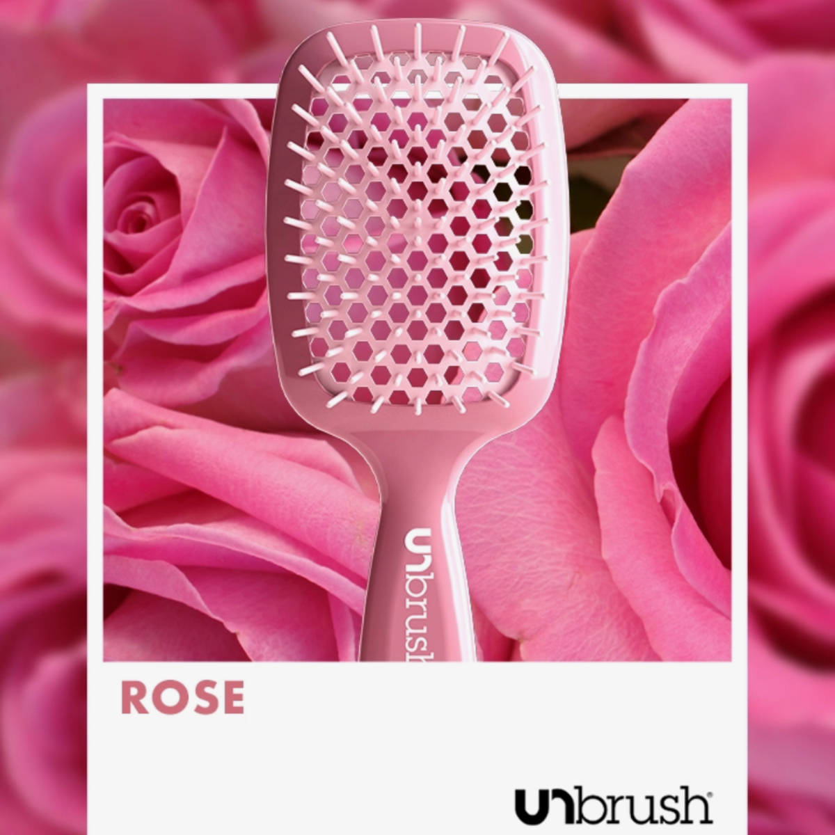 Die UNbrush Detangling-Haarbürste mit Wabendesign wird vor einem Hintergrund aus rosa Rosen gezeigt.