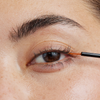 Eine Nahaufnahme einer Person, die das XLASH Xlash Wimpernserum (1 ml) mit einem dünnen Pinsel auf den oberen Wimpernkranz aufträgt.