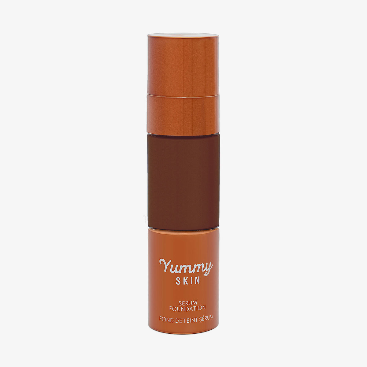 Eine halbtransparente und bronzene Flasche Yummy Skin Serum Foundation 23N mit dunkelbraunem Inhalt.