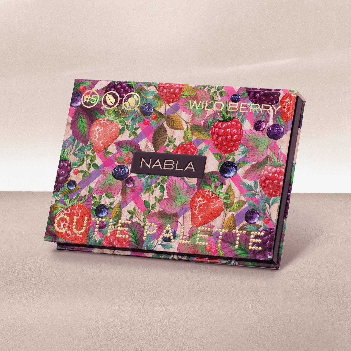 Geschlossene NABLA Cutie Palette „Wild Berry“ mit buntem Früchtedesign aus Erdbeeren, Himbeeren und Blättern auf rosa Hintergrund.