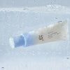Die Relief Sun Aqua Fresh Rice + B5 SPF 50+ Tube umgeben von Sprudelwasser