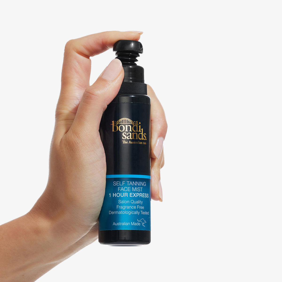 Hand hält eine Flasche Self Tanning Face Mist One Hour Express vor einem weißen Hintergrund