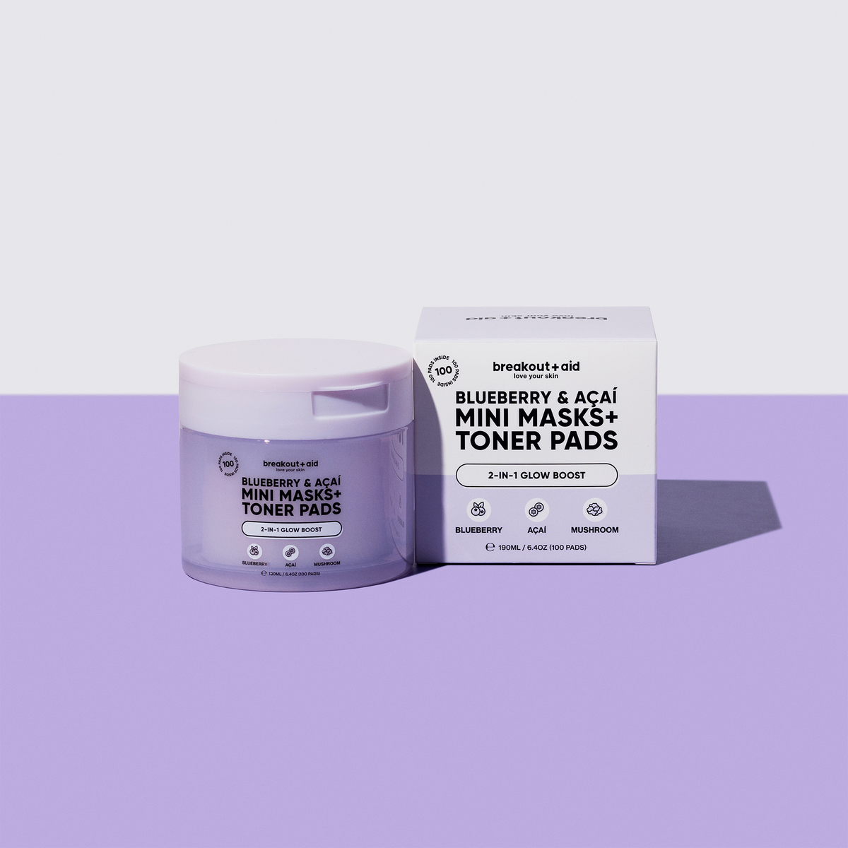 Ein hellviolettes Töpfchen und eine dazu passende Schachtel mit breakout+aid Mini-Masken in den Sorten Blueberry & Açaí sowie Toner-Pads.