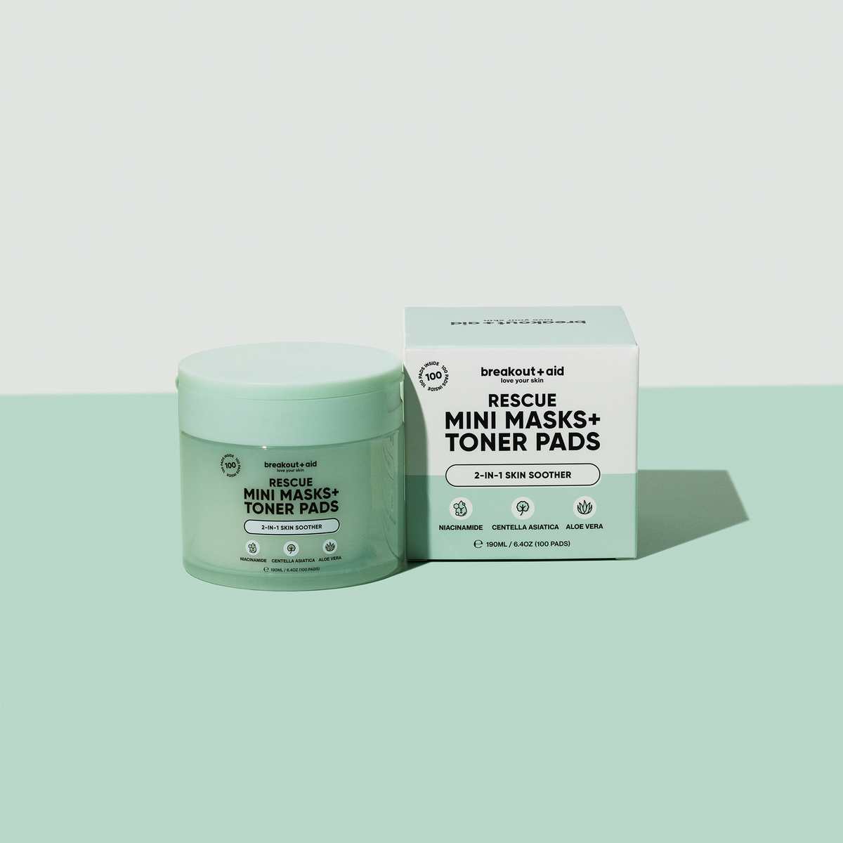 Eine hellgrüne Dose und eine dazu passende quadratische Schachtel mit breakout+aid Rescue Mini Masks und Toner Pads.