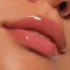 Nahaufnahme von glänzenden rosafarbenen Lippen und glatter Haut, die das Colour Cushion Juicy Lip Oil von Catrice Cosmetics präsentieren.