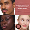 Drei Personen mit unterschiedlichen Hauttönen tragen das „Yummy Skin Flushed Essentials Blush & Lip Kit“ von Danessa Myricks Beauty, abgebildet mit Farbmuster und Döschen.