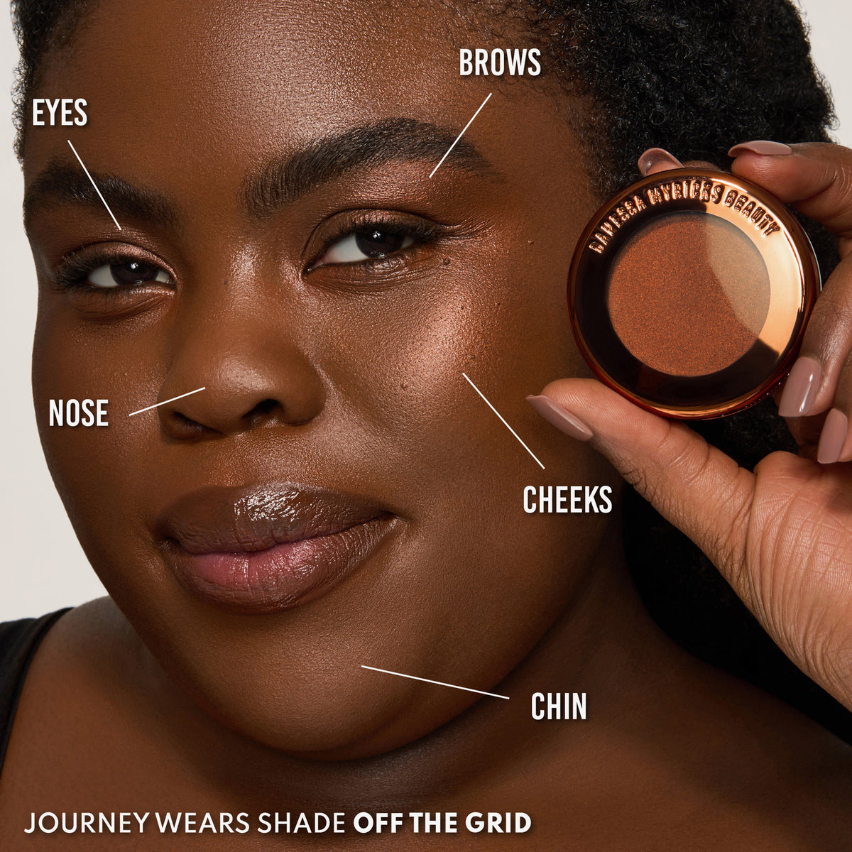 Eine Frau hält eine Dose Yummy Skin Blurring Balm Powder Lowlighter Off The Grid neben ihr Gesicht lächelt. 