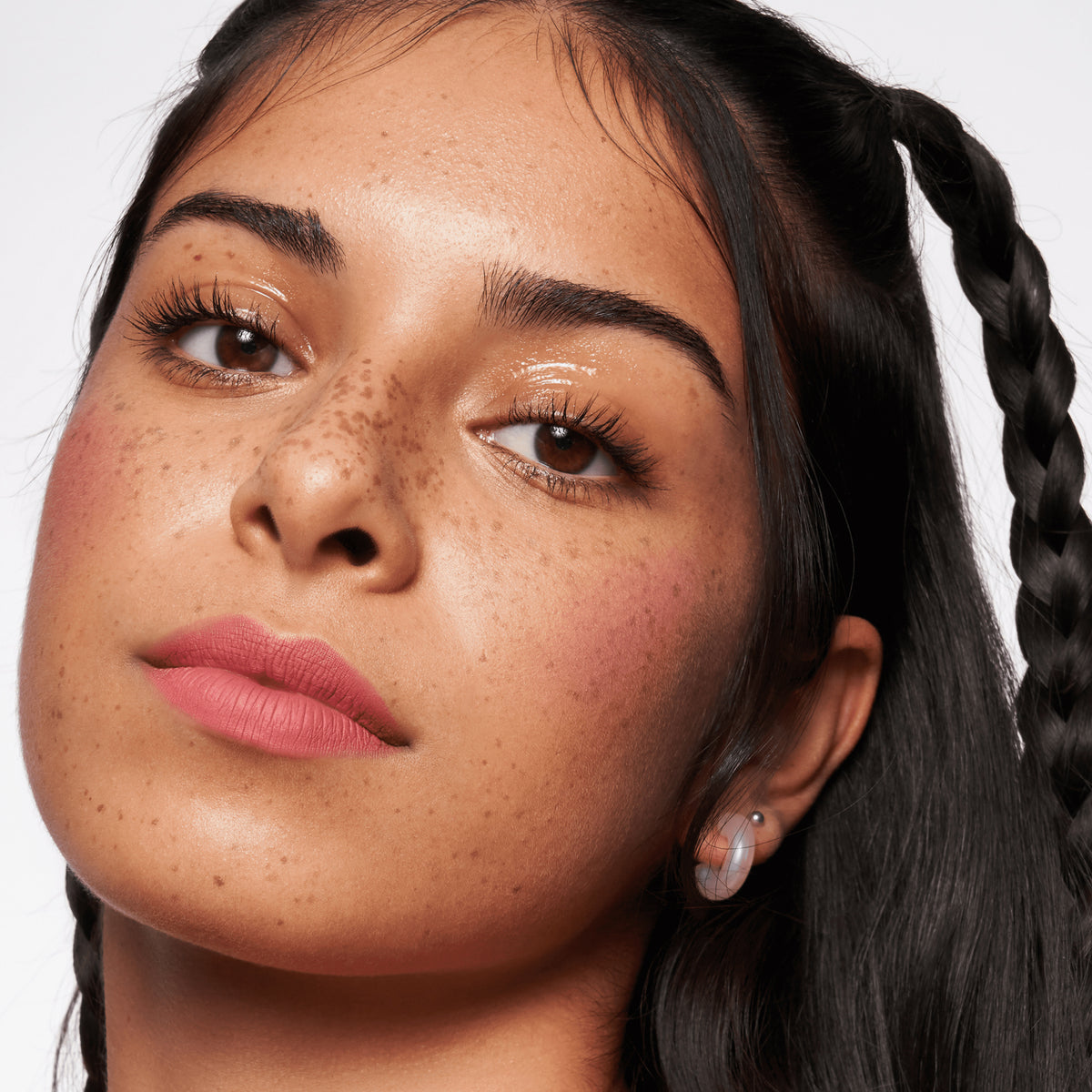 Frau mit mittlerem Hautton, rosa Lippenstift und dunkelbraunem Haar präsentiert ihren strahlenden Look mit MAGIC FILTER Glow Booster 20 Medium.