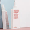 Eine Flasche Happy Campers Wearable Treatment vor einem nassen Spiegel.