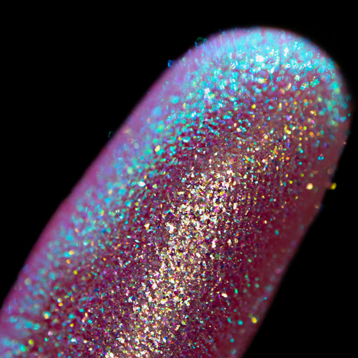 Nahaufnahme einer Fingerspitze, die in den Opal Moonstone Loose Multichrome Eyeshadow Boujee Bae getaucht wurde und türkis-rosa glitzert.