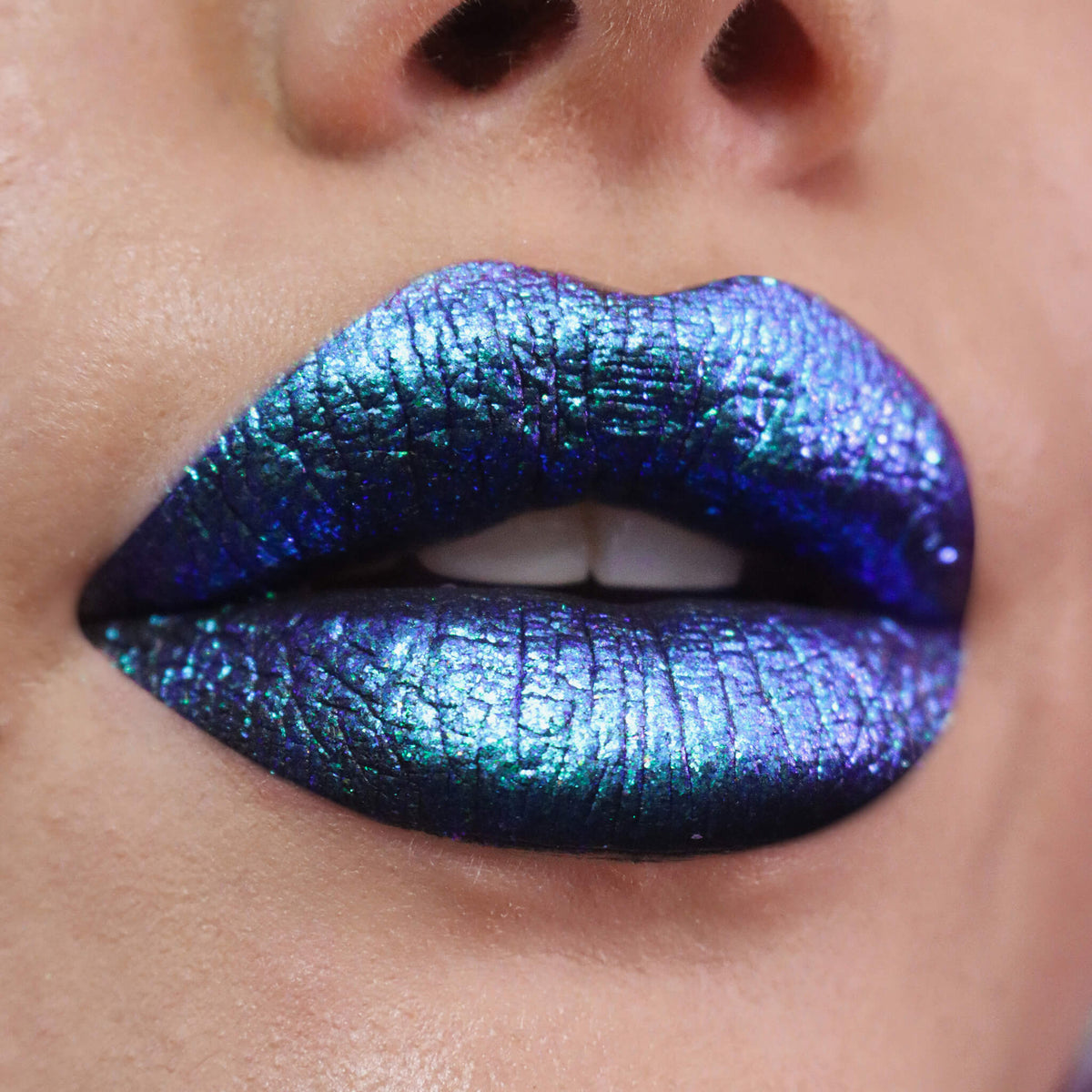 Nahaufnahme von Lippen, die mit dem Opal Moonstone Loose Multichrome Eyeshadow Moody Cow geschminkt wurden und einen blau-lilanen irisierenden Schimmer offenbaren.