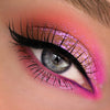 Nahaufnahme eines Auges mit dramatischem Eyeliner und pink-lila schimmerndem Opal Multichrome Loose Eyeshadow in Cozy.