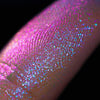 Nahaufnahme einer Fingerspitze, die in den Opal Multichrome Loose Eyeshadow Nightfall getaucht wurde und pink-blau glitzert.