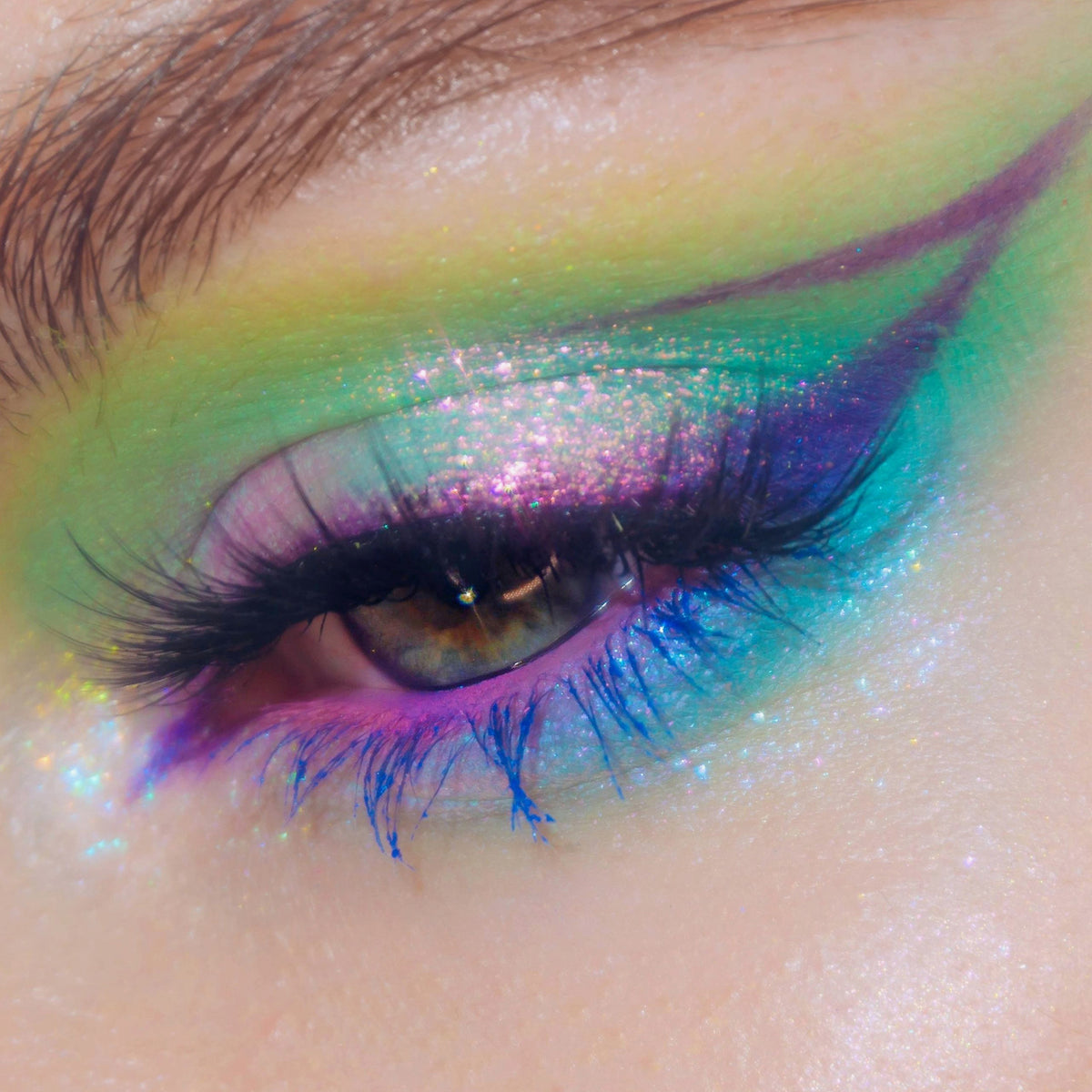 Nahaufnahme eines Auges mit dramatischem Eyeliner und grünlich-rosa schimmerndem Opal Multichrome Loose Eyeshadow in Rockabye Baby.