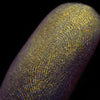 Nahaufnahme einer Fingerspitze, die in den Opal Multichrome Loose Eyeshadow Shooting Star getaucht wurde und gelb-grün-gold glitzert.