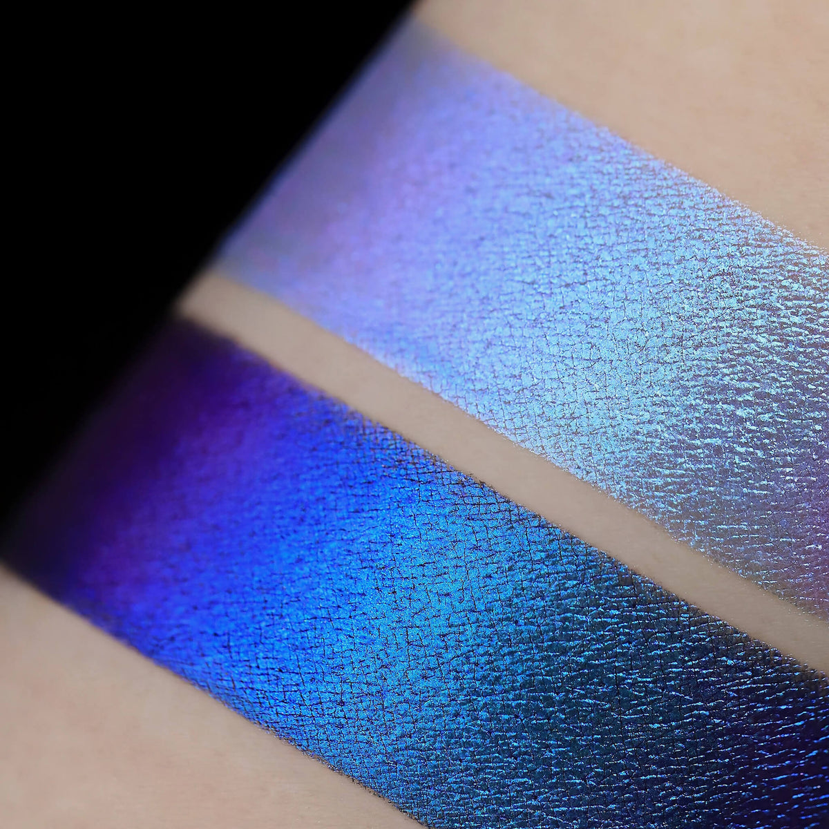 Zwei schimmernde Muster des Pastel Duochromes Loose Eyeshadow Ribbon mit unterschiedlichen Grundierungen; eins mit der Black Base (lila-blau), eins mit der Fix Potion (hellviolett).