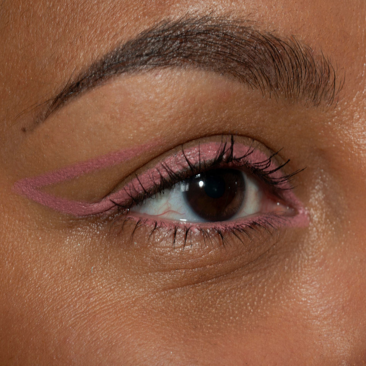 Nahaufnahme eines Auges zeigt einen kreativen Nude-rosanen Eyeliner, der mit dem Crayon Soft von LH Cosmetics kreiert wurde.