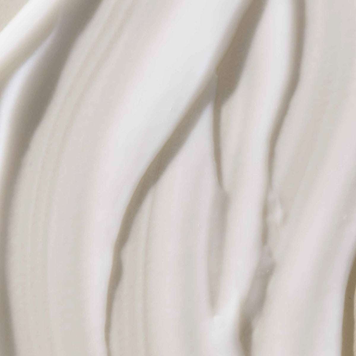 Nahaufnahme der Living Proof No Frizz Smooth Styling Cream mit einer cremeweißen Textur.