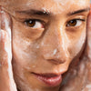 Eine Frau reinigt ihr Gesicht mit Lumene Nordic-C [VALO] Exfoliating Gel Cleanser, die Hände umrahmen ihr Gesicht in einer Nahaufnahme.