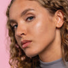 Nahaufnahme eines Gesichts mit klarer, strahlender Haut. Auf der Wange ist ein fast unsichtbarer Pickel-Patch von Mario Badescu aufgetragen.