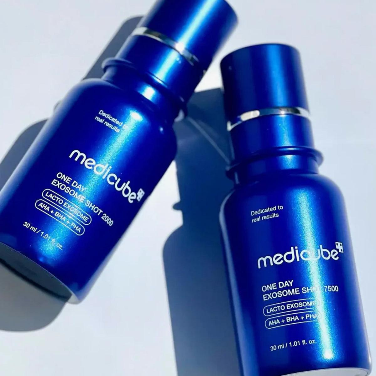Zwei blaue Flaschen von medicube One Day Exosome Shot Pore Ampoule 7500 sind auf weißem Hintergrund abgebildet.