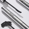 Zwei silberne Wimperntusche-Tuben mit der Aufschrift Femuline™ von Mesauda Beauty, mit einer geschwungenen Bürste und einem schwarzen Wimperntusche-Klecks daneben.