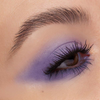Nahaufnahme eines Auges mit kräftigem lavendelfarbenem Lidschatten, langen Wimpern und NABLA Cosmetics Cupids Arrow Longwear Stylo.