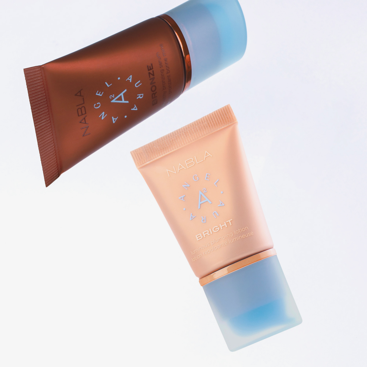 Die beiden Tuben Angel Aura Bronze und Bright aus dem NABLA Cosmetics Sun-Kissed Glow Set schweben vor weißem Hintergrund.