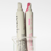 Zwei Tuben der NERDS. Peptide + Hyaluronic Acid Lip Treatment stehen in einem klaren Glasbecher.