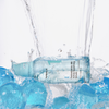 Das No.1 Pantothenic B5 Active Soothing Serum von numbuzin ruht auf blauen Gelkugeln, über die sich das Wasser ergießt.
