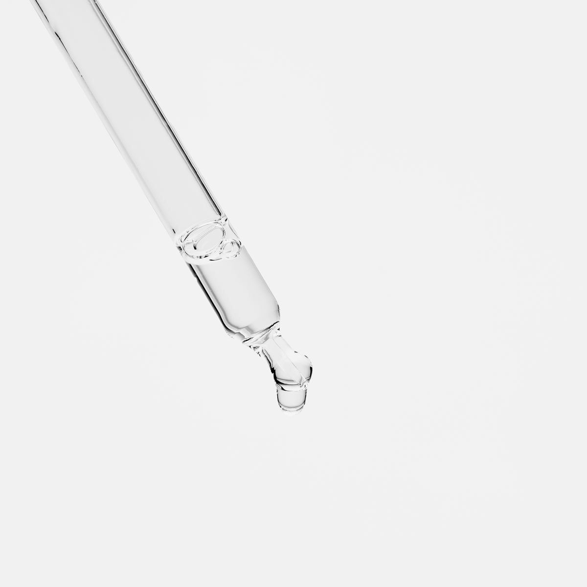Ein durchsichtiger Tropfer gibt einen einzelnen Tropfen Scandinavian Biolabs Bio-Pilixin® Serum+ Women vor einem weißen Hintergrund ab.