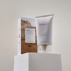 Eine Tube Madagascar Centella Soothing Cream steht neben der Schachtel auf einem weißen Sockel.