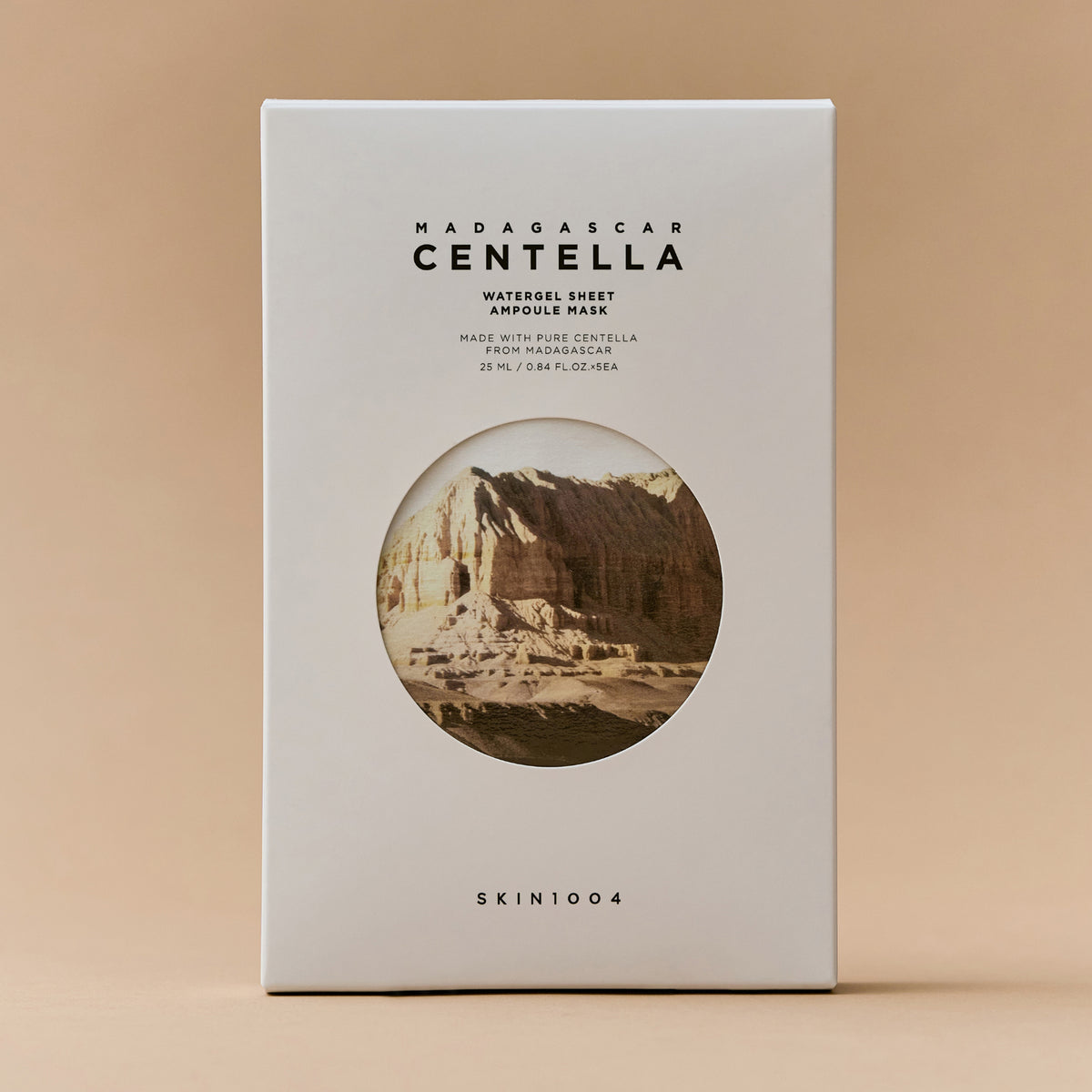 Madagascar Centella Watergel Sheet Ampoule Mask in einer weißen Box mit einem Bild einer felsigen Landschaft auf der Vorderseite vor einem beigen Hintergrund.