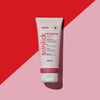 Auf einem diagonalen roten und rosa Hintergrund ist eine rosa-weiße Tube Rouge365 Essential Cream abgebildet.