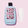 Blaue Flasche Sun Tan Sealer mit einem weißen Cremeklecks rechts auf rosa Hintergrund.