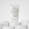 Eine Tube Barrier Restoring Hydrating Cream steht auf einer weißen geometrischen Plattform.
