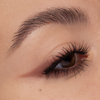Nahaufnahme eines braunen Auges mit langen Wimpern, einem mit Cupid’s Arrow Longwear Stylo gezogenen Lidstrich und einer gepflegten Augenbraue.