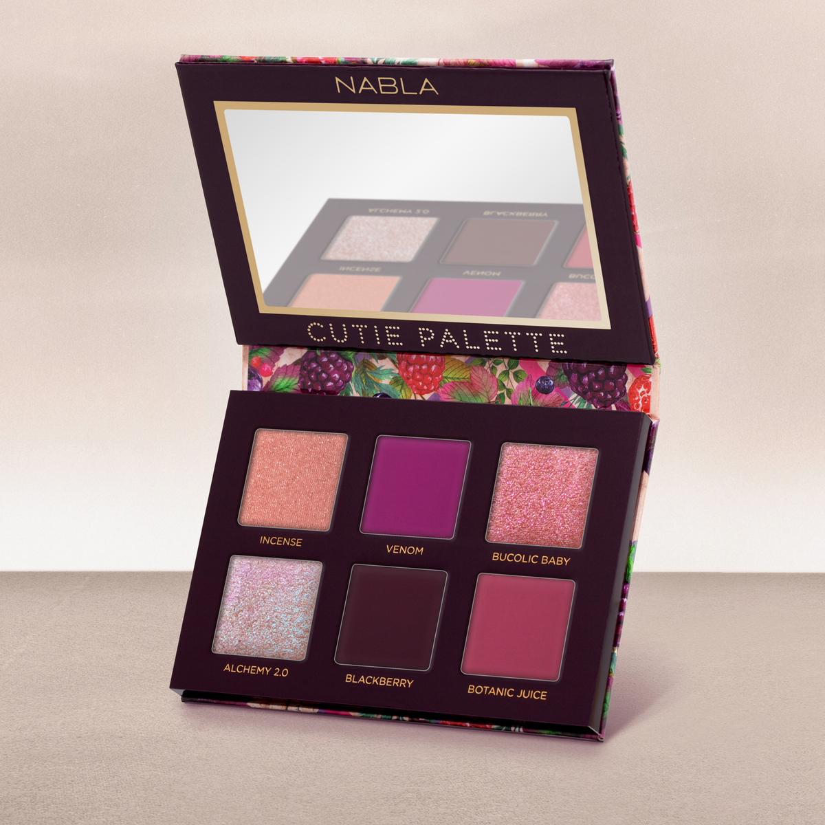 Geöffnete NABLA Cutie Palette „Wild Berry“ mit sechs schimmernden und matten Lidschatten in Beerentönen, dekoriert mit buntem Früchtedesign.
