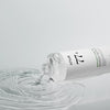 Aus einer Flasche Heartleaf 77 % Soothing Toner wird Flüssigkeit auf eine glatte Oberfläche gegossen, wodurch sanfte Wellen im Wasser entstehen.