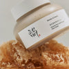 Nahaufnahme des Ground Rice and Honey Glow Mask-Tiegel auf einer Honigwabe.