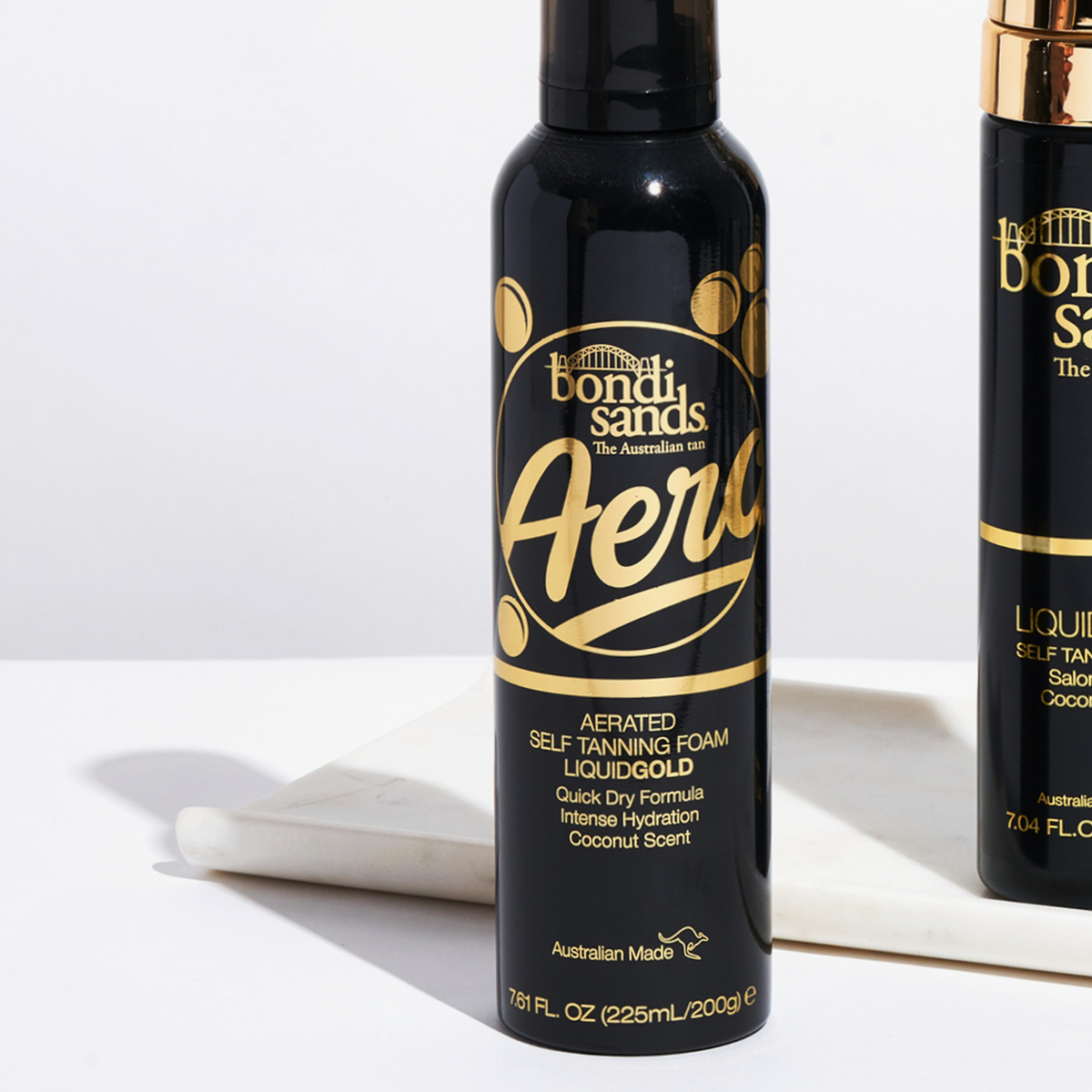 Eine Flasche PURISH Aero Self Tanning Foam Liquid Gold auf einer weißen Marmorfläche.