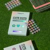 Breakout+aid Cute Dots – Akne-Pflaster gegen Pickel und Hautunreinheiten mit schillernden Stern- und Herz-Aufklebern auf grünem Gras.