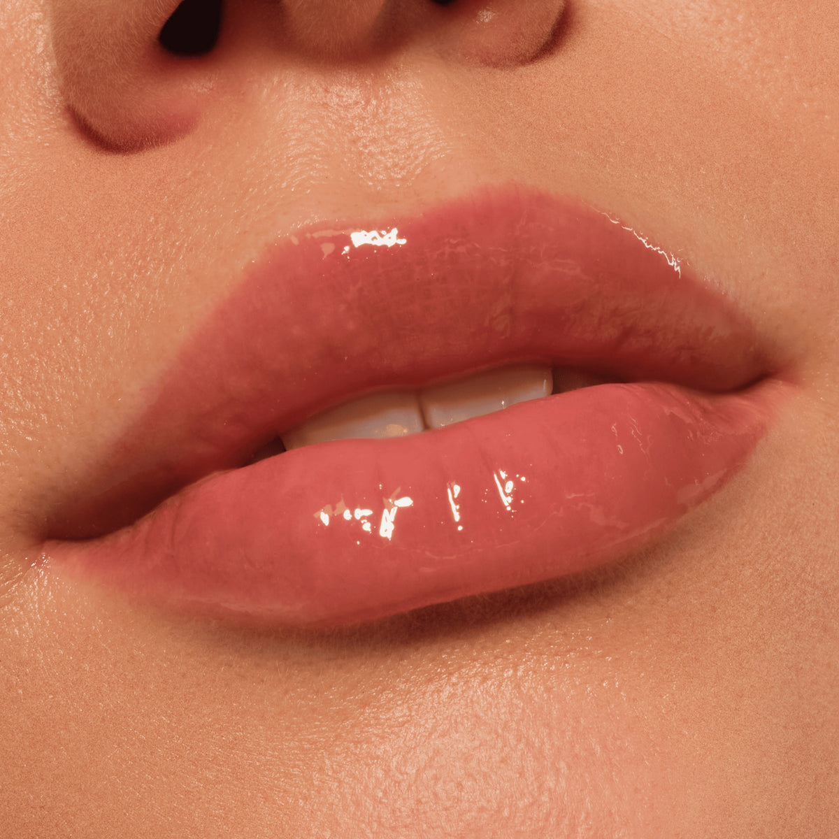 Nahaufnahme glänzender Lippen mit dezentem braun-beigem Catrice Colour Cushion Juicy Lip Oil für ein natürliches, gepflegtes Finish.