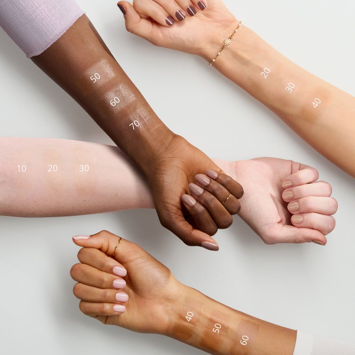 Drei Arme unterschiedlicher Hautfarben zeigen Farbmuster des MAGIC FILTER Glow Booster.