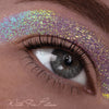 Nahaufnahme eines Auges mit leuchtend schillerndem Glitzerlidschatten; Text: Mit Fix Potion aufgetragen.